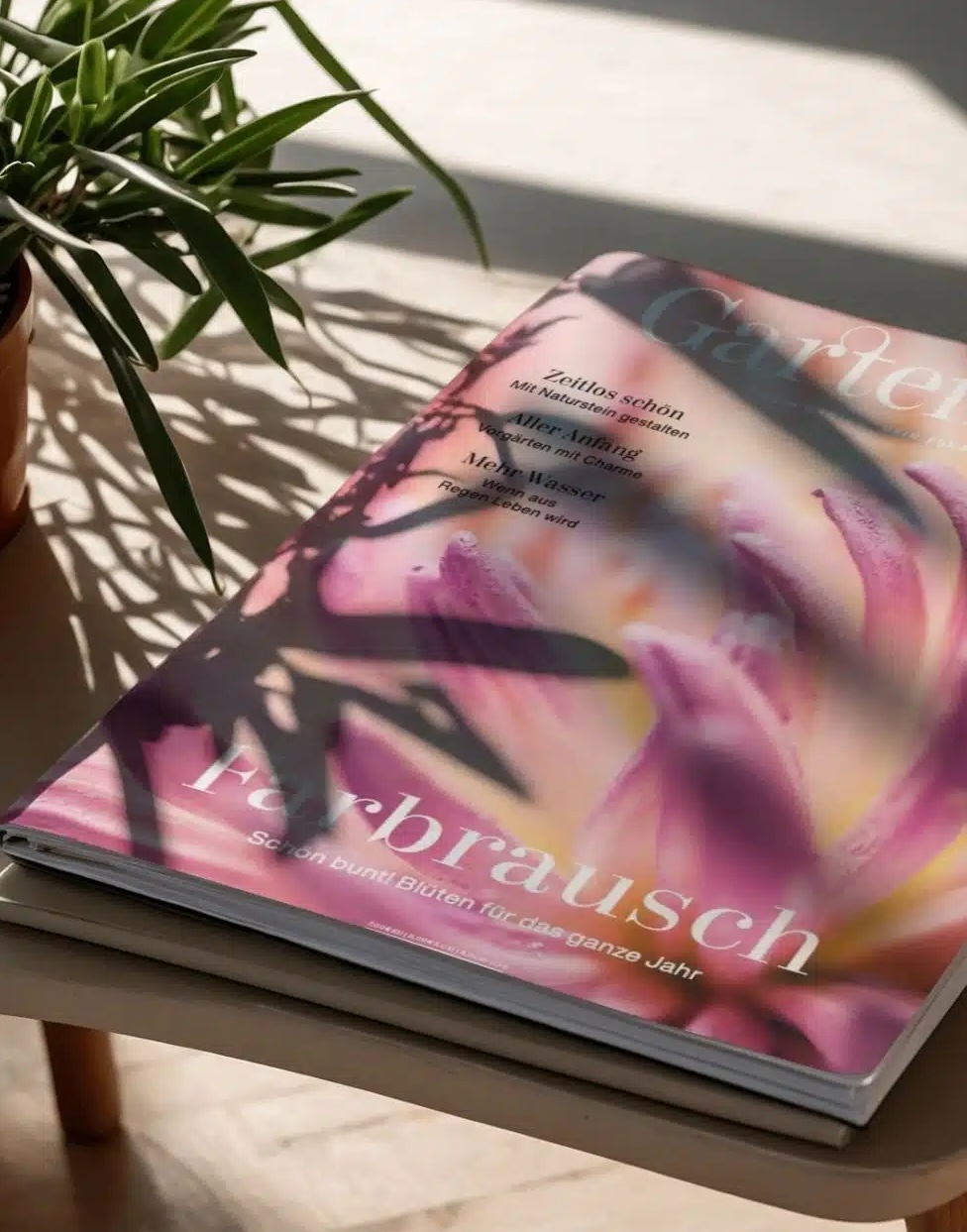 Teaserbild_GatrenArt_980x1251 Cover des GartenArt Magazins mit einer Hand, die Pflanzen hält, und bunten Illustrationen.